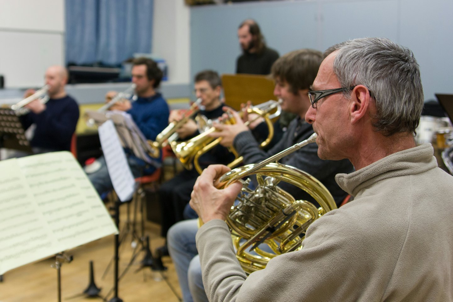 Un musicista suona il corno francese durante una prova di un ensemble di ottoni.